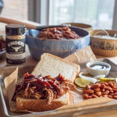 barbecue sandwich with bbq sauce and baked beans on a baking tray next to other food items