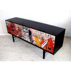 a black and red dresser with graffiti on it