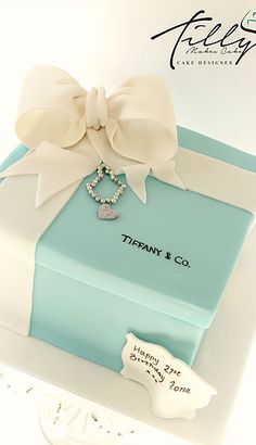 a blue box with a white bow and necklace on it that says tiffany & co