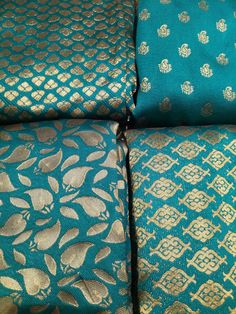 four pieces of blue and gold brocades on a bed sheet with matching pillows