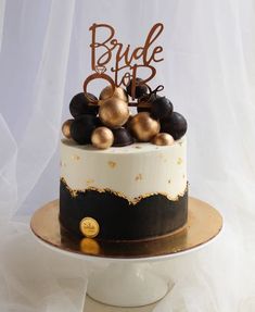 a white and black wedding cake with gold decorations