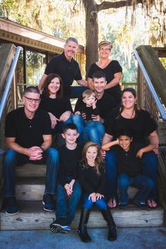 a group of people sitting on the steps in front of stairs with trees behind them