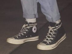 a person wearing blue jeans and black sneakers