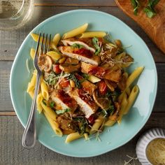 a blue plate topped with pasta and chicken