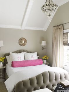 a bedroom with a large bed and chandelier hanging from it's ceiling