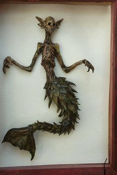 a shadow cast of a creature in a wooden frame, with its arms outstretched and legs spread out