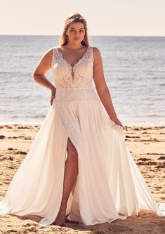 a woman standing on the beach wearing a white dress