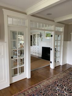 an empty living room with white walls and wood flooring on the wooden floor, along with glass doors that lead into another room