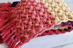 two crocheted scarves sitting on top of each other