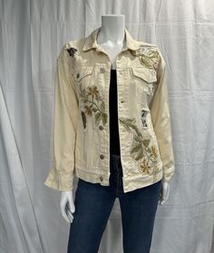 a mannequin wearing a jean jacket with embroidered flowers on the front and sides