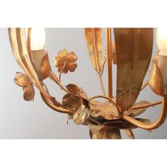 a gold chandelier with flowers and leaves on it