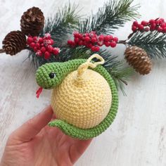 a crocheted christmas ornament in the shape of a turtle on a pine branch