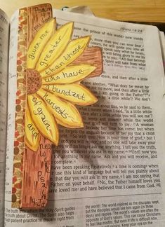 an open bible with a flower painted on it