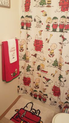 a bathroom with snoopy christmas shower curtain and rug