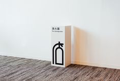 a white box with a black handle on the floor in front of a white wall