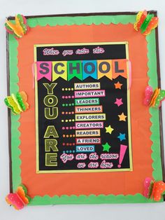 a school bulletin board is decorated with colorful paper decorations and writing on the front cover