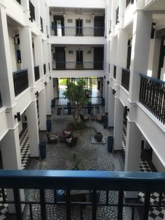 an indoor courtyard with potted plants and black and white tiles