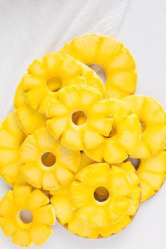 yellow flowers are arranged on a white tablecloth and in the shape of pineapples