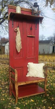 an old outhouse is painted red and has a bench in front of the door