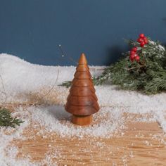 a small wooden christmas tree sitting on top of snow