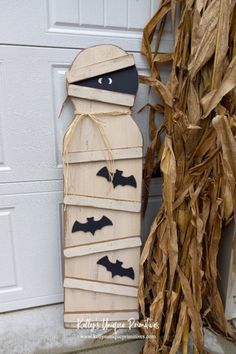 a halloween decoration made out of wood sticks with bats hanging from it's sides