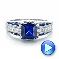 an engagement ring with a blue sapphire and diamonds on the side, in white gold