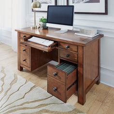 a wooden desk with a computer on top of it