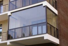 an apartment building with glass balconies on the top and second story above it