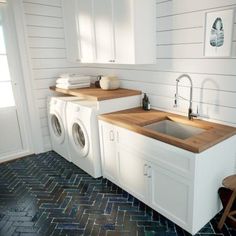 a washer and dryer in a white laundry room with blue tile flooring