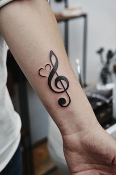 Treble clef tattoo with a heart design on a person's forearm. Treble Clef Guitar Tattoo, Music Wrist Tattoos, Small Wrist Tattoos For Women, Small Wrist Tattoo, Music Note Tattoo, Guitar Tattoo, Music Tattoo Designs, Note Tattoo, Small Wrist Tattoos