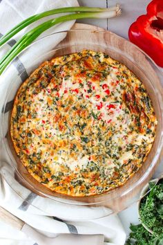 a pizza sitting on top of a white plate covered in cheese and toppings next to vegetables