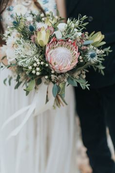 the bride and groom are holding their bouquets