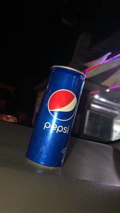 a can of pepsi on the dashboard of a car