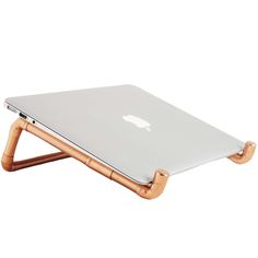 an apple laptop sitting on top of a wooden stand