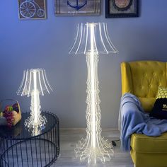 two lamps sitting next to each other on a table near a chair and lamp shade