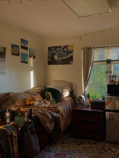 a messy bedroom with lots of clutter on the floor and pictures on the wall