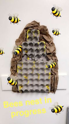 bees nest in progress on the back of an egg carton with honeybees around it