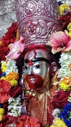 a statue is surrounded by flowers and other decorations