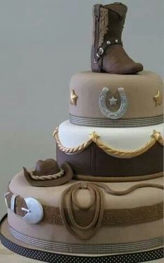 a three tiered cake with cowboy boots on top and other items around the bottom