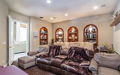 a living room with couches and chairs in it's centerpiece, along with three arched windows