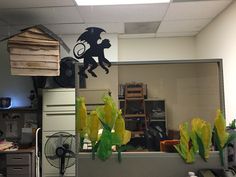 an office cubicle decorated with paper cutouts and plants in front of the window