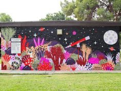 a colorful mural on the side of a building with plants and animals painted on it