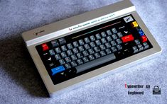 an old computer keyboard sitting on top of a gray carpeted floor next to a mouse