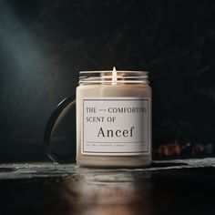 a candle is sitting on a table with the words, scent of ancef