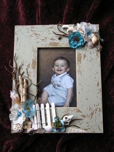 an old photo frame is decorated with blue flowers and white pickets on a red velvet background