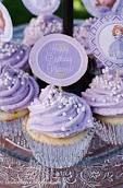 cupcakes with purple frosting and white sprinkles are on a glass plate