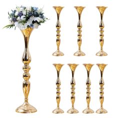 a group of gold candlesticks with flowers in them