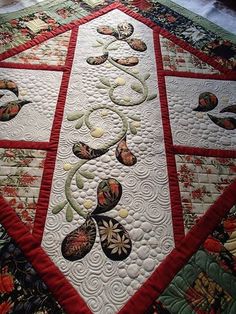 a quilted table topper with many different designs on it's edges and sides