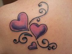 the back of a woman's shoulder with two hearts on it and swirls