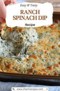 a hand holding a piece of spinach dip over a casserole in a pan